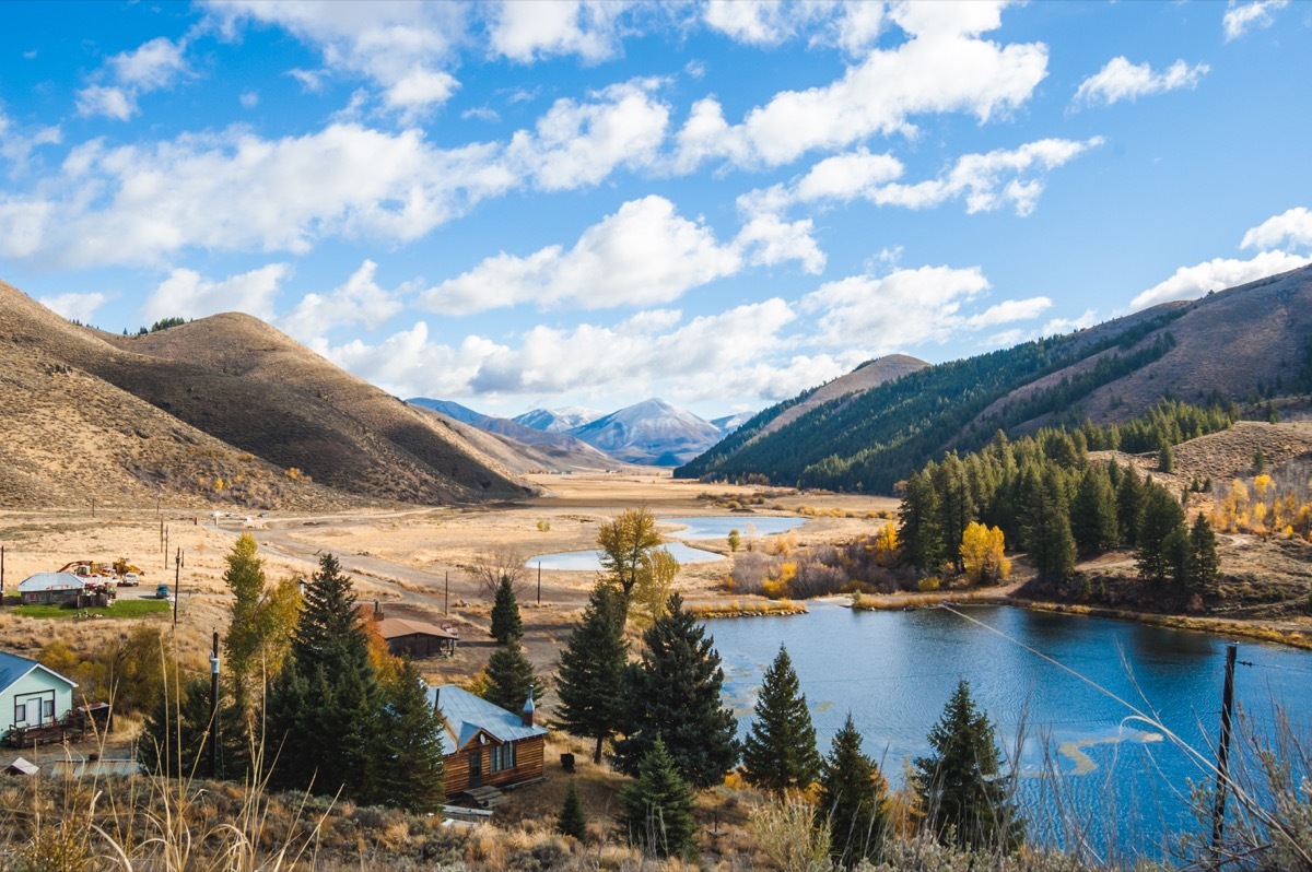 Partly cloudy blue sky over mountain landscape, lake, and countryside properties Deer Creek in Hailey Idaho