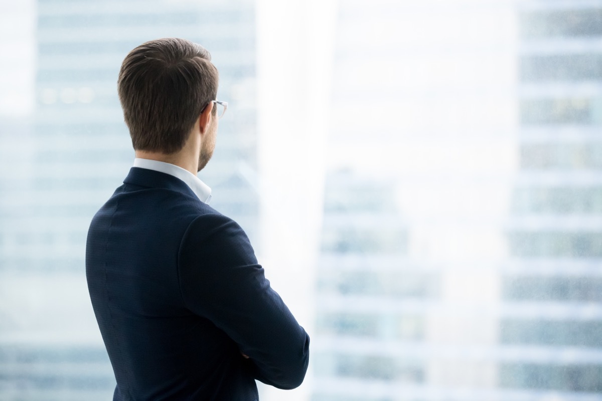 man looking out window