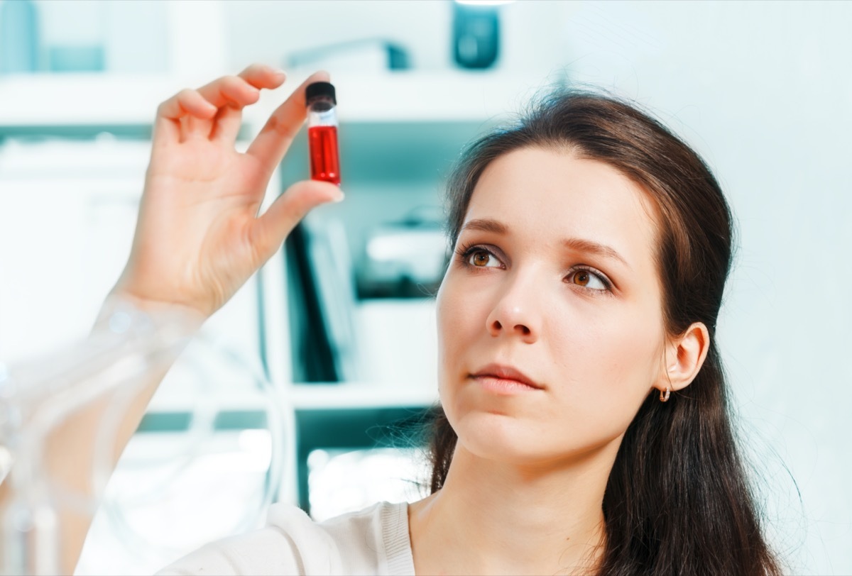 Laboratory assistant with a sample of blood in a test tube