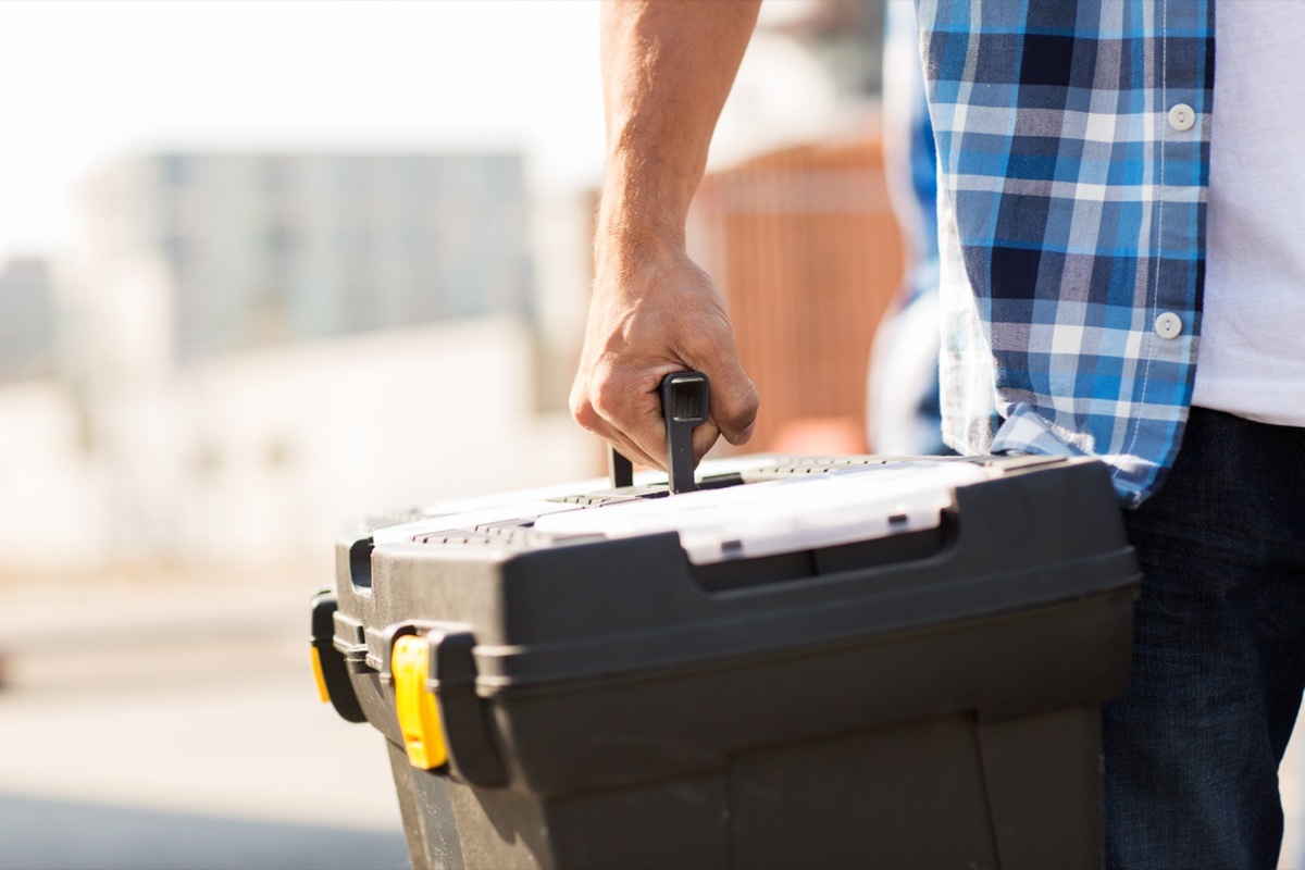 Man carrying his black tool box.