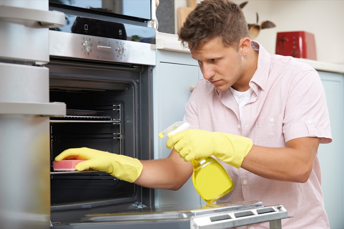 Man cleaning oven rack