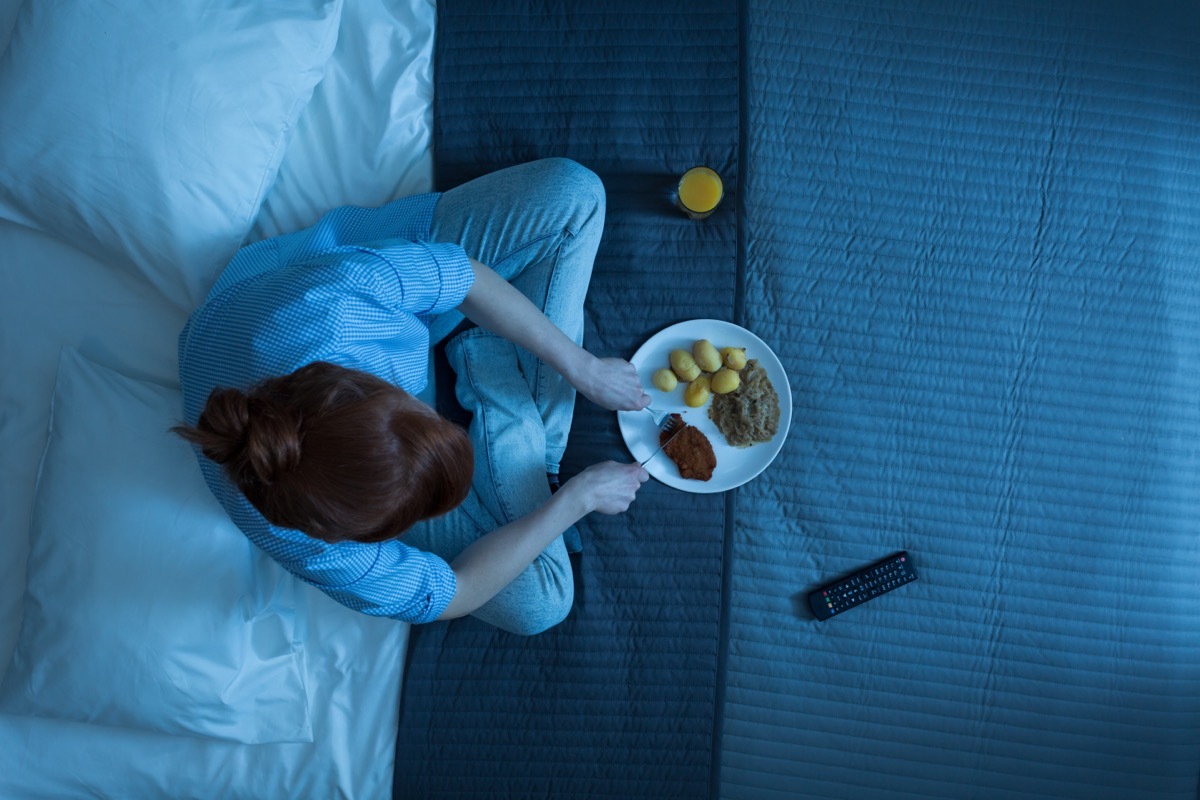 Woman eating dinner before bed.