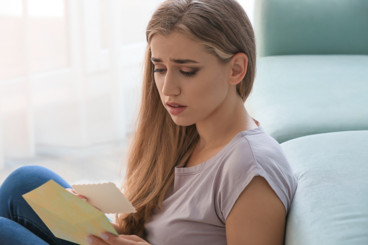 sad woman reading greeting card