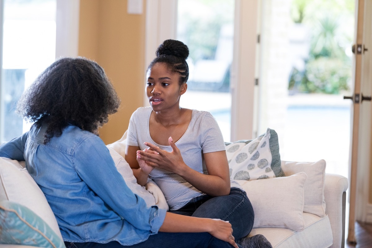 woman sitting on a couch with a friend, nervous about apologizing