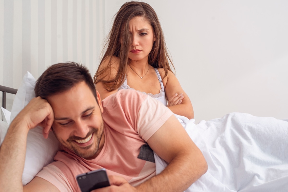 Girlfriend looking angry at boyfriend on phone