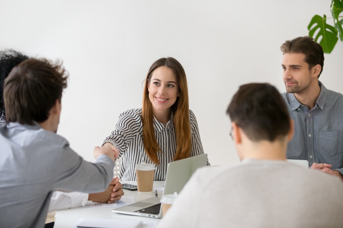 Coworkers Shaking Hands During Meeting