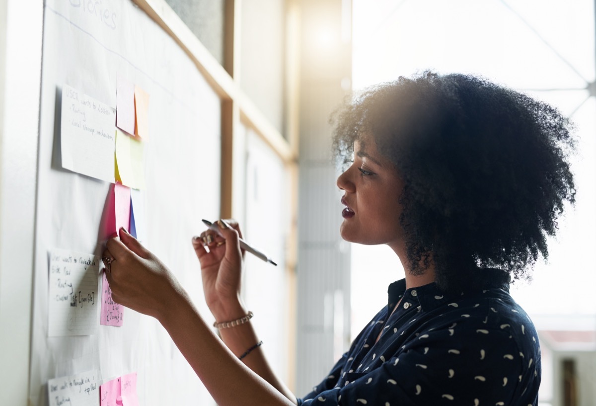 woman writing her goals on a board