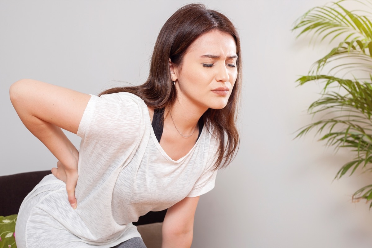 Woman experiencing back ache.