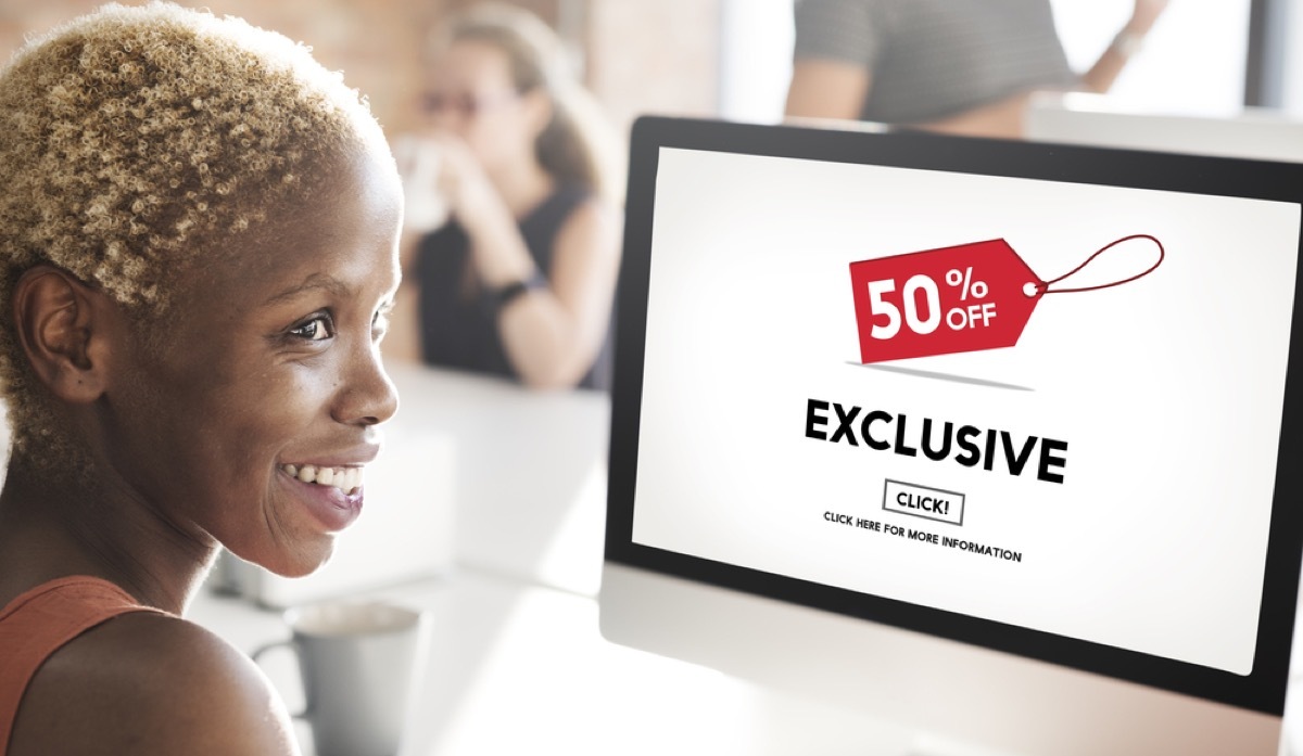 black woman online shops on computer, which shows exclusive deal