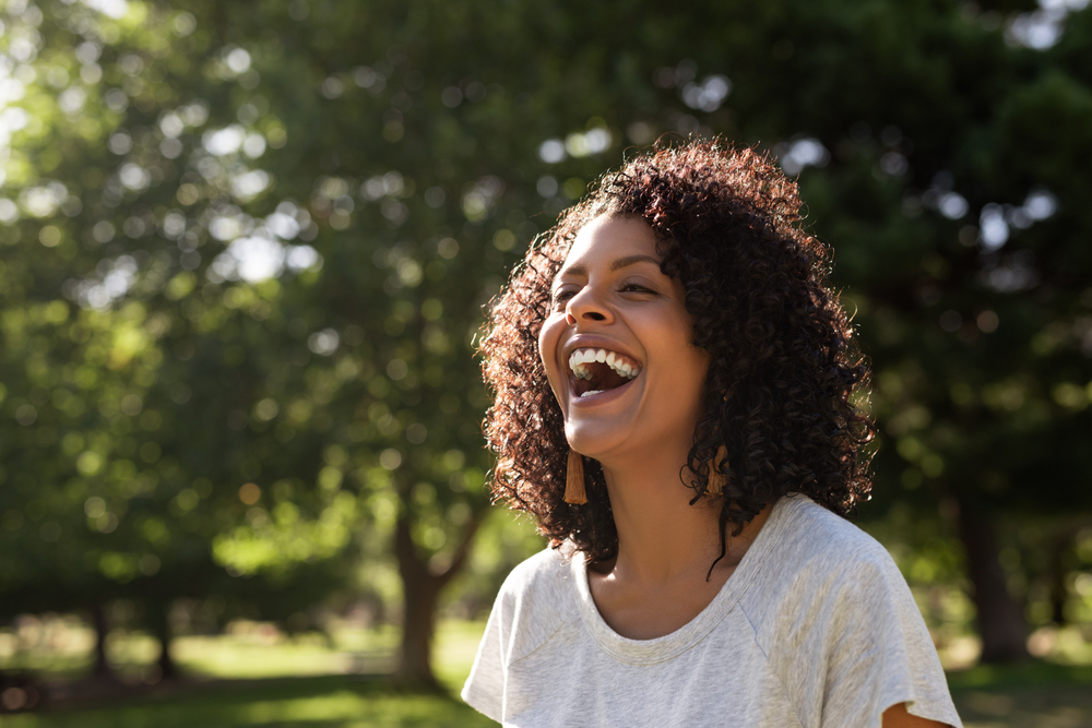 woman smiling alone in the woods