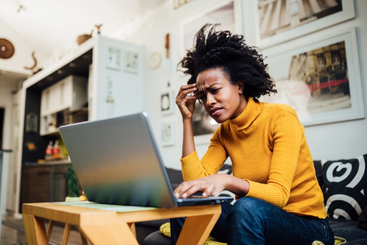 female freelancer working from home using her laptop and encountering some problems concerning her business