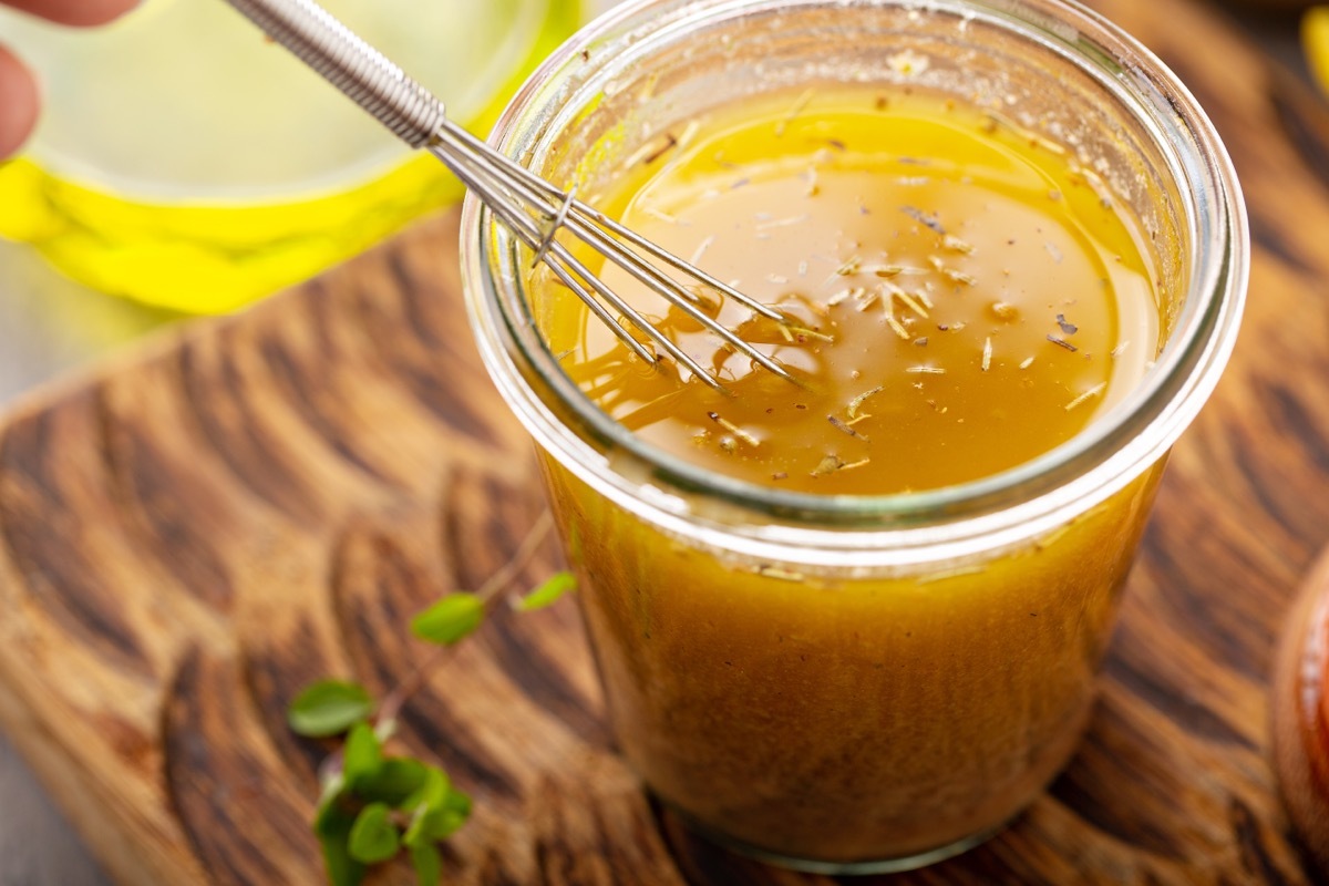 homemade vinaigrette with whisk in glass jar