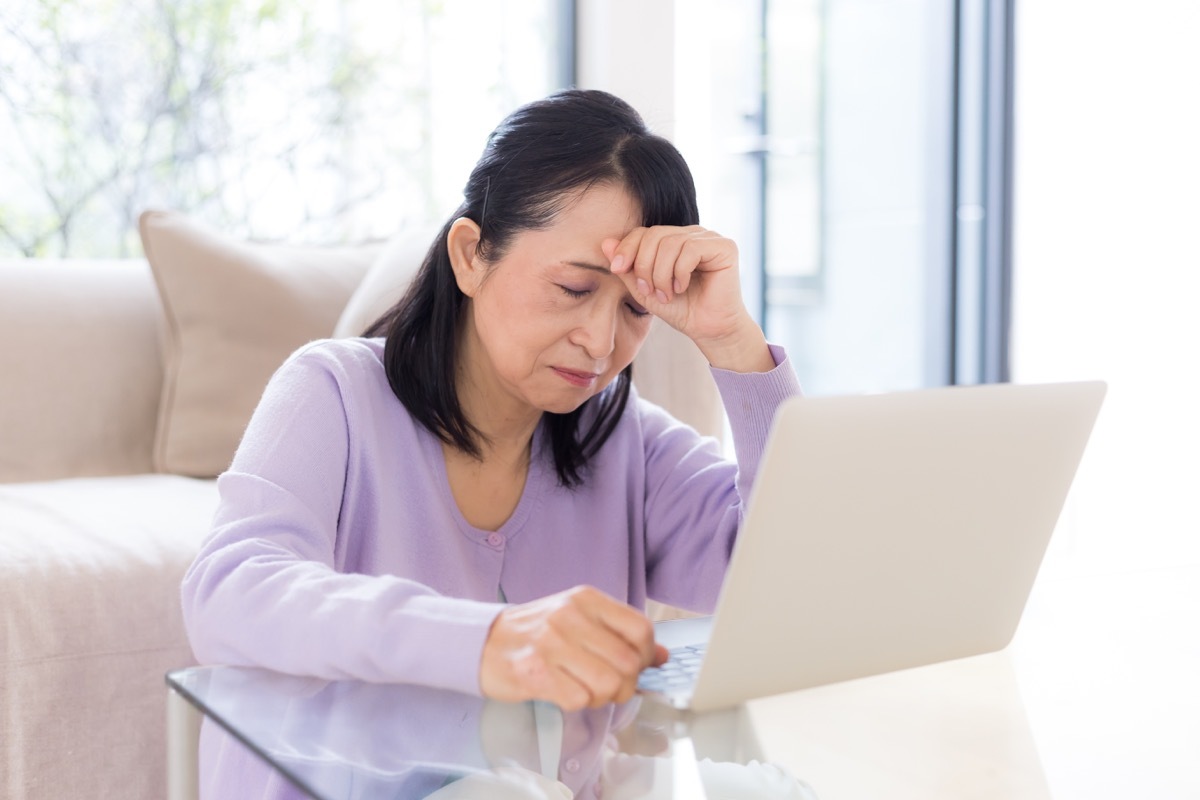 woman with a headache at a laptop