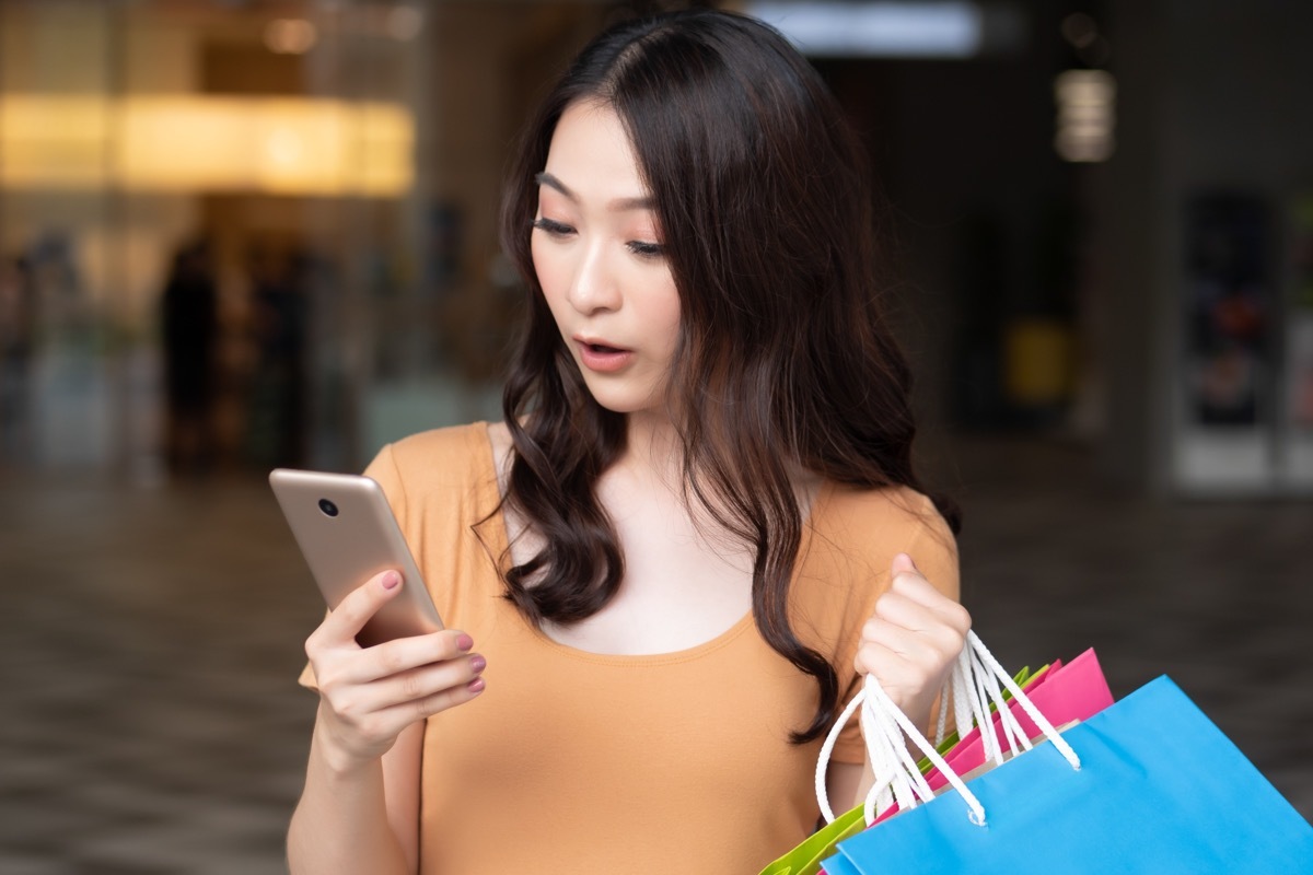 Woman looking at her phone while shopping at the mall