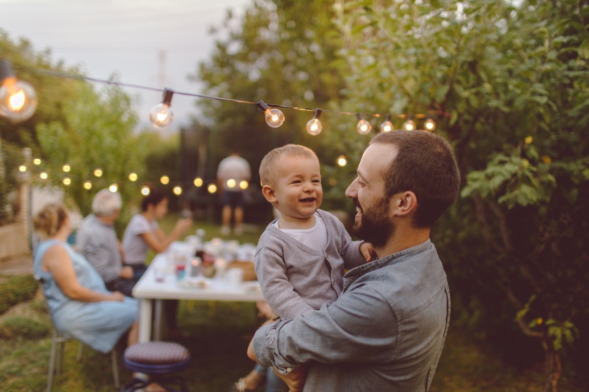 young father holding baby outside