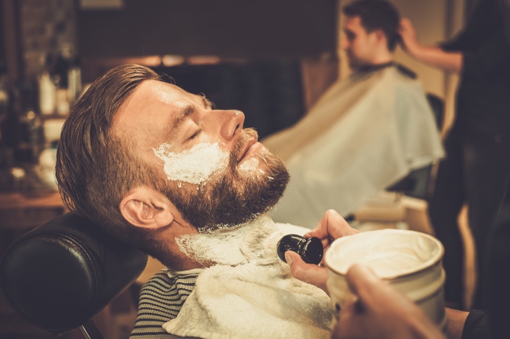 man getting a shave from a barber