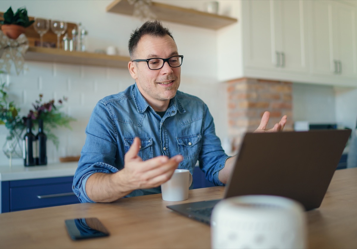 Happy adult man having a video call with a laptop