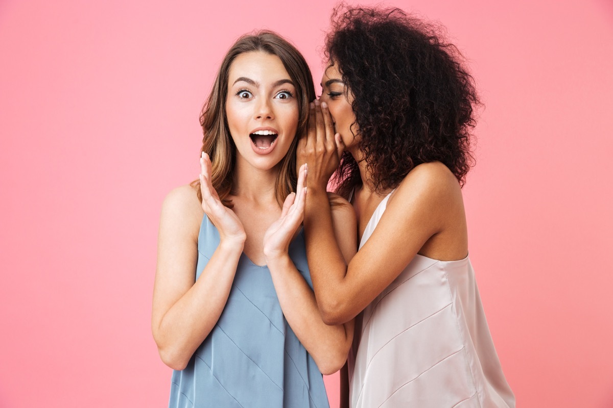 two friends gossiping against a pink background