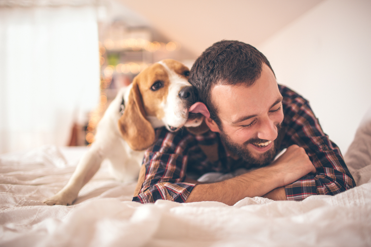 Young smiling man affectionate with his dog