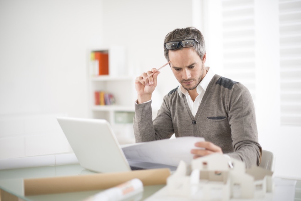 man looking at papers at the office, should i be single