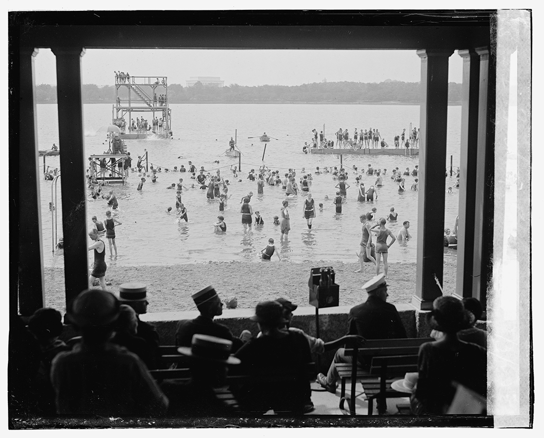 people sit in a pavilion watching the beach in the 1920s