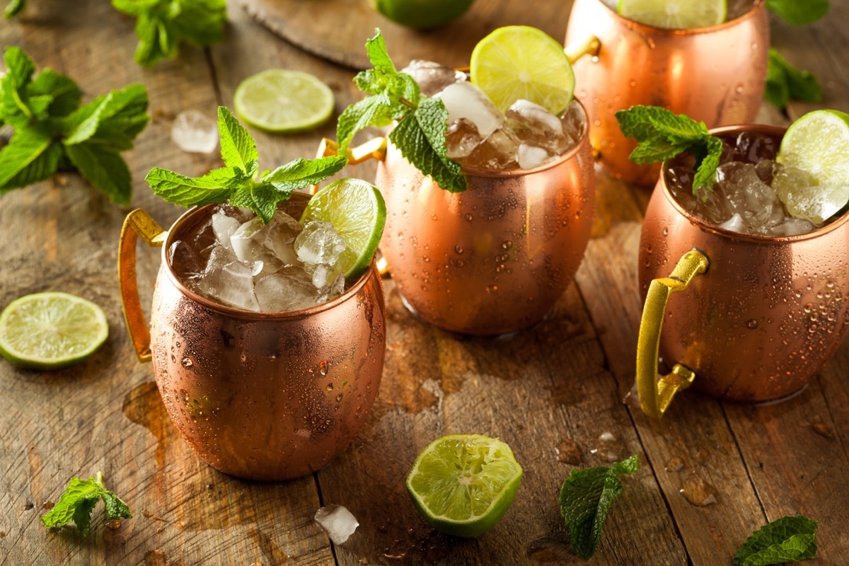 whiskey ginger, ginger beer, clear glass on wooden table, lime