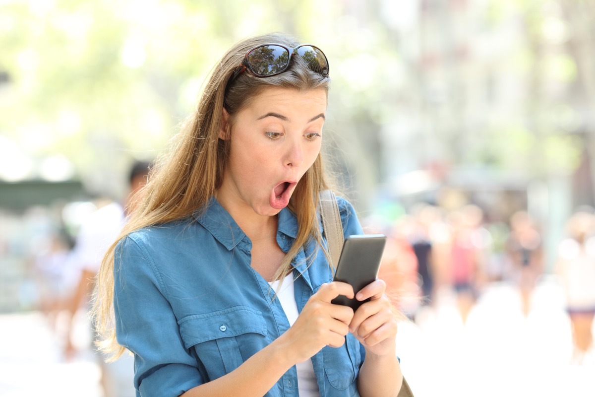 Woman on phone surprised reading viral dating story