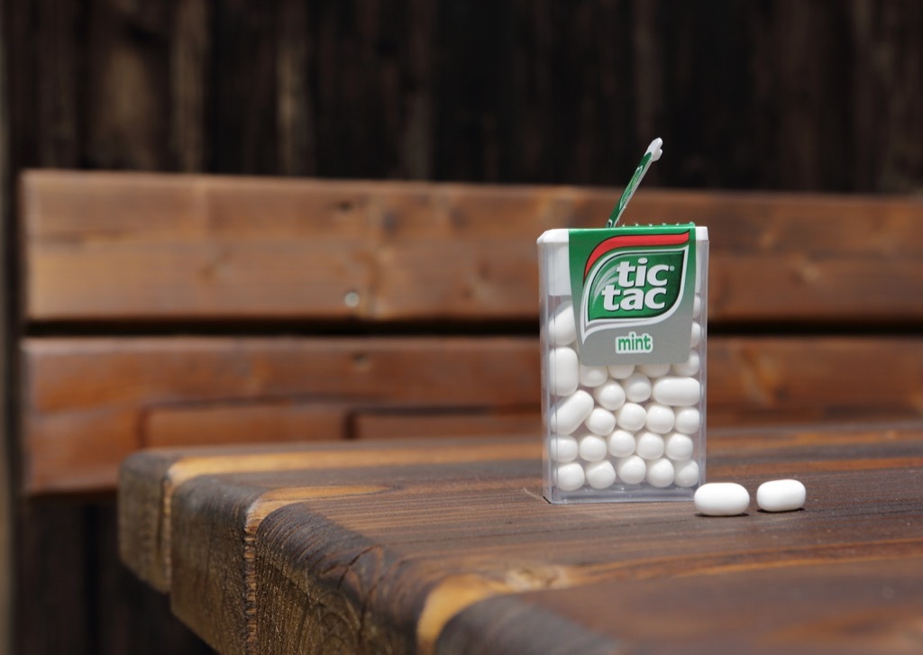 an open mint white tic tac box resting on a wooden table