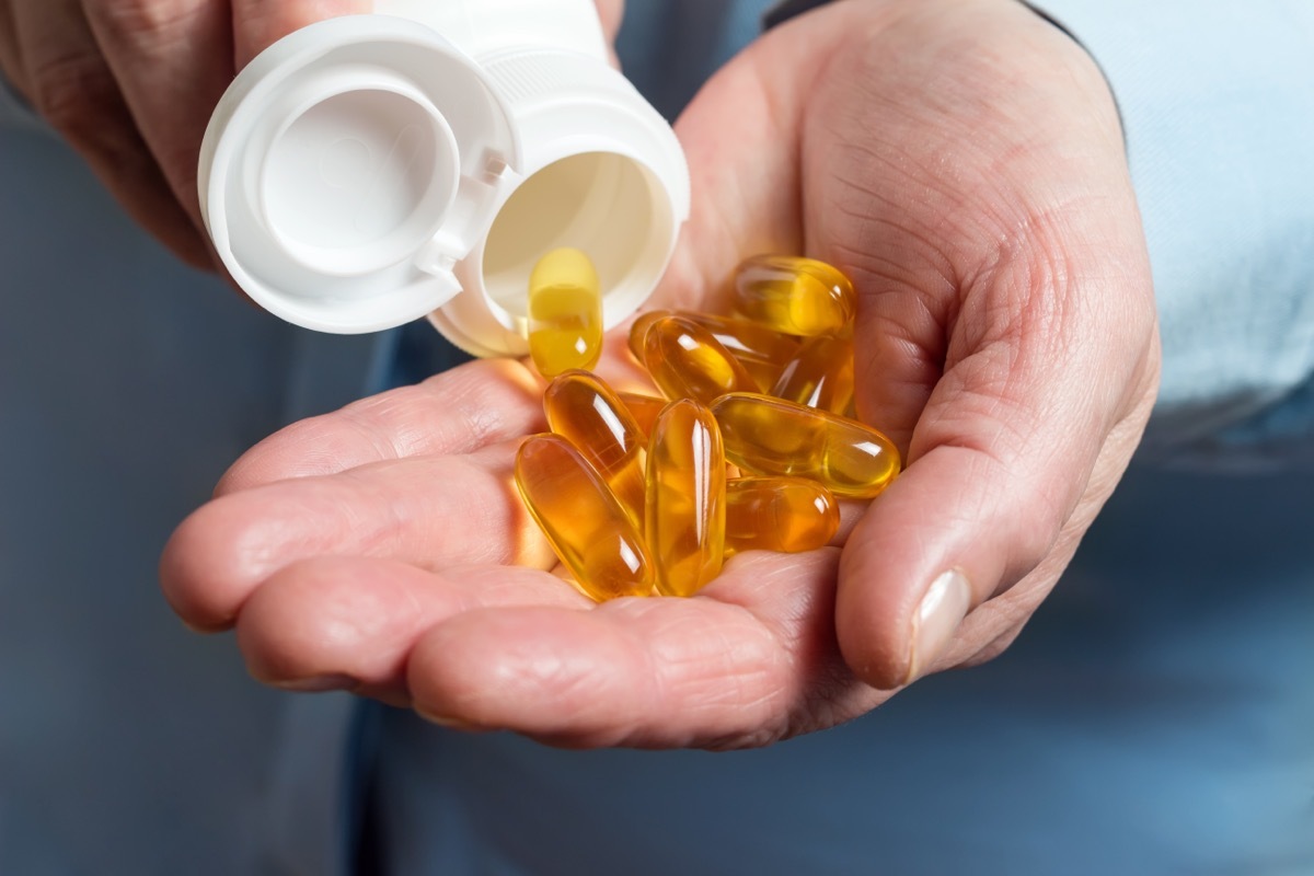 omega-3 fatty acid supplements being poured into a person's hand