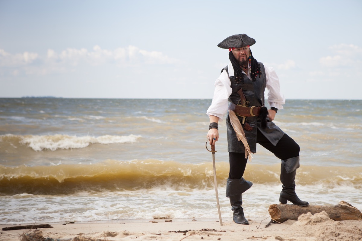 man dressed as pirate on beach - pirate jokes