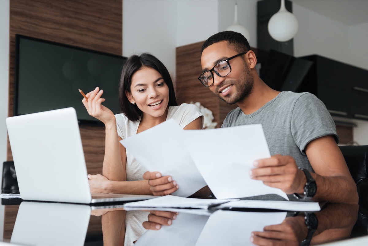 young white woman and young black man working at home together