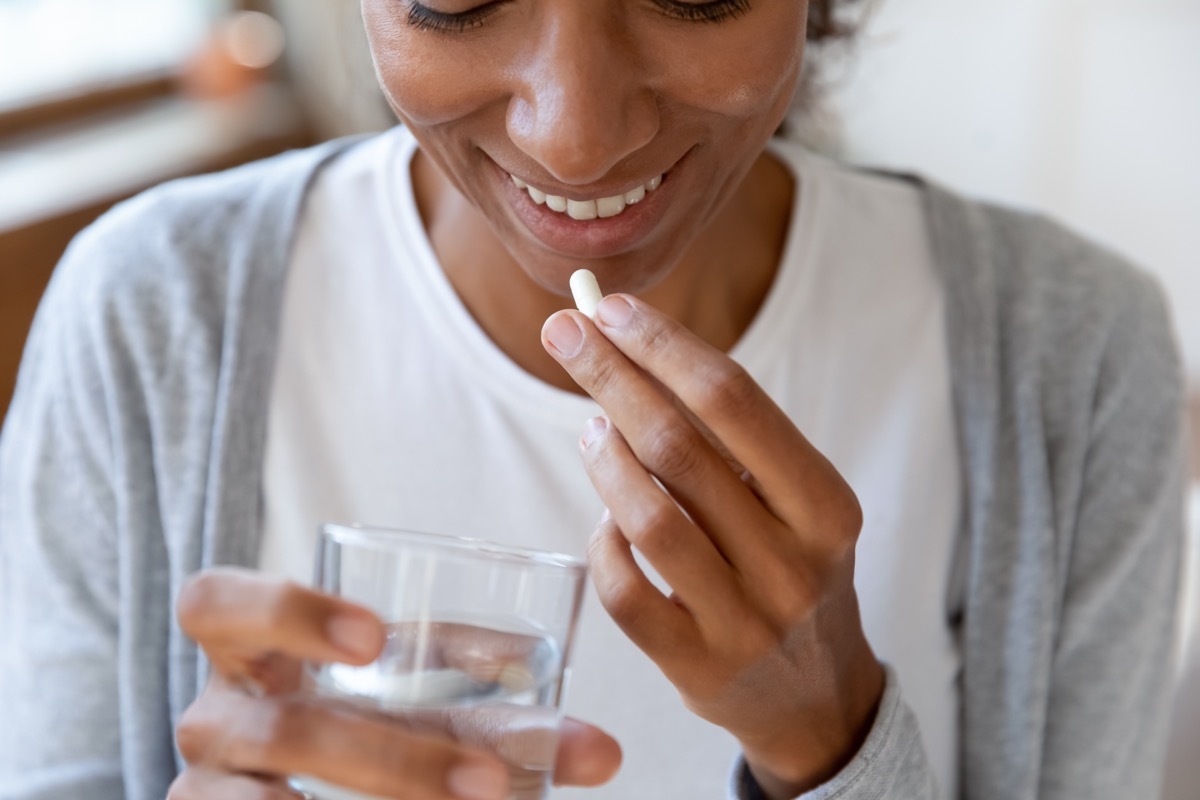 young woman taking supplement