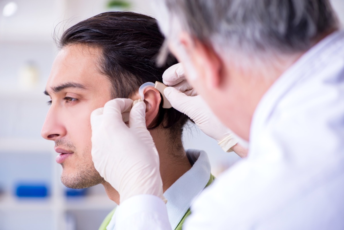 doctor fitting hearing aid