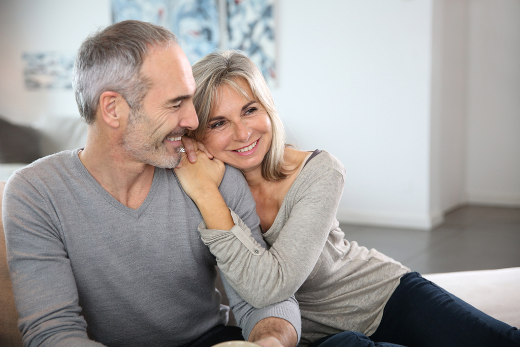 happy couples in their 50s sitting on couch