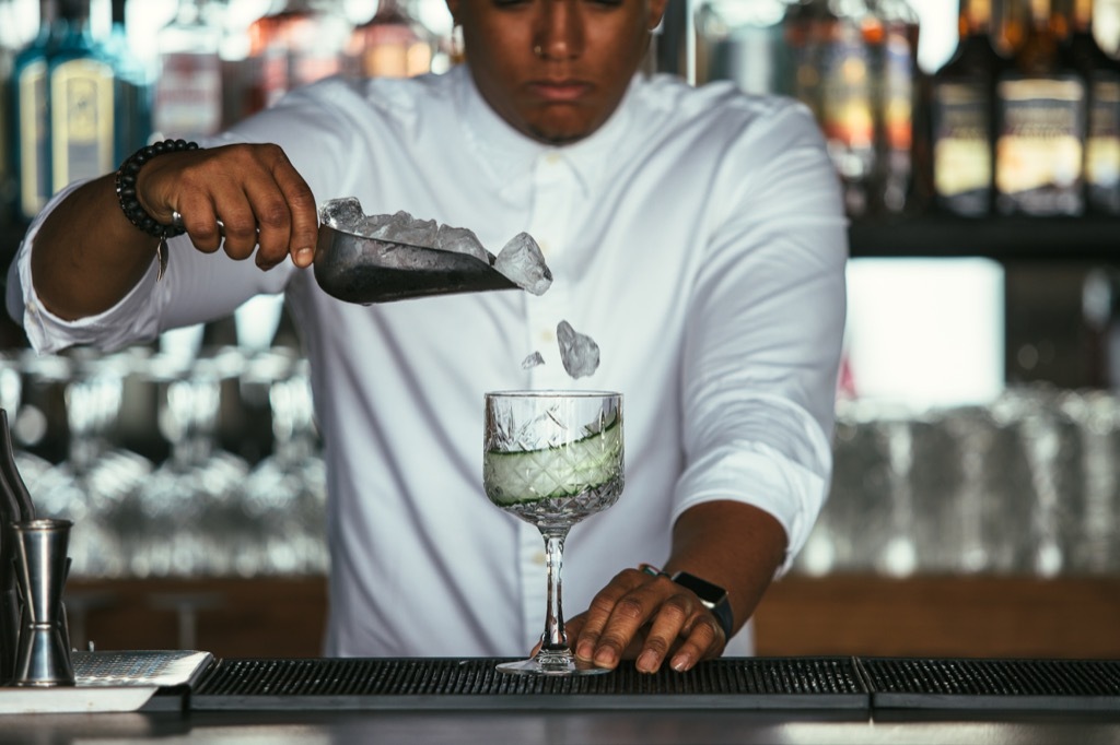 Man Pouring Ice Cubes in Glass