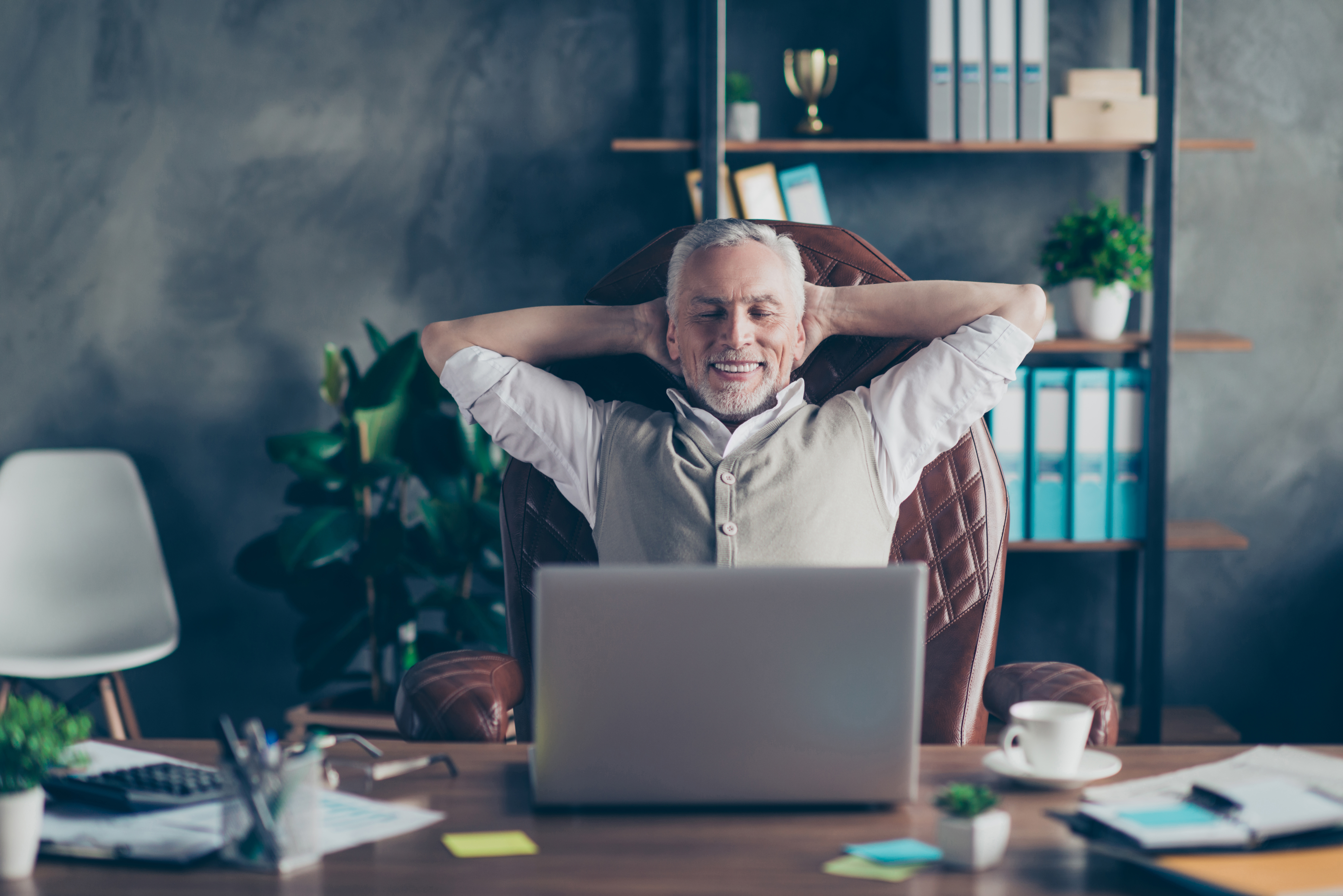 man sitting back in his office looking at his computer