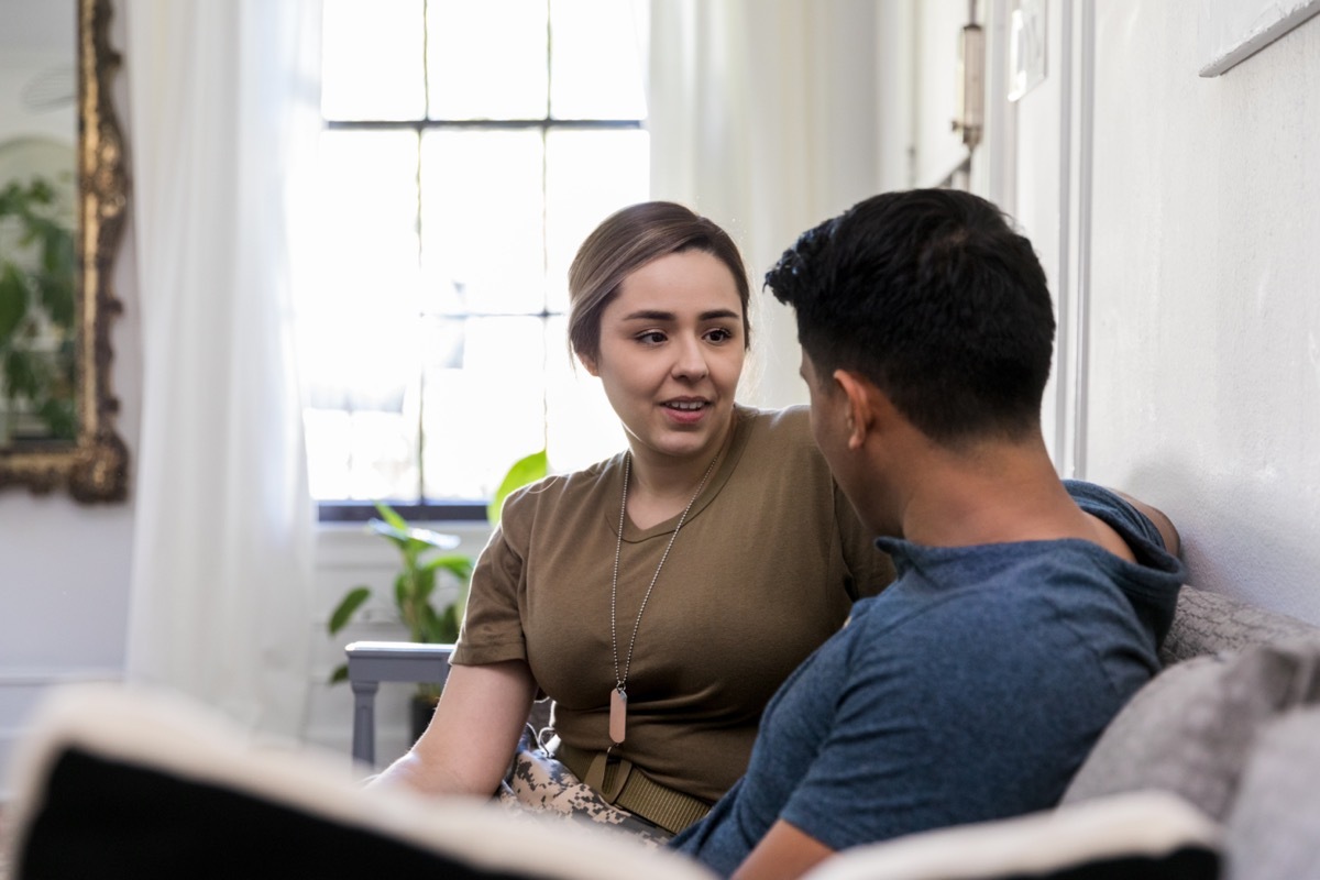 man and woman sitting on a couch and talking