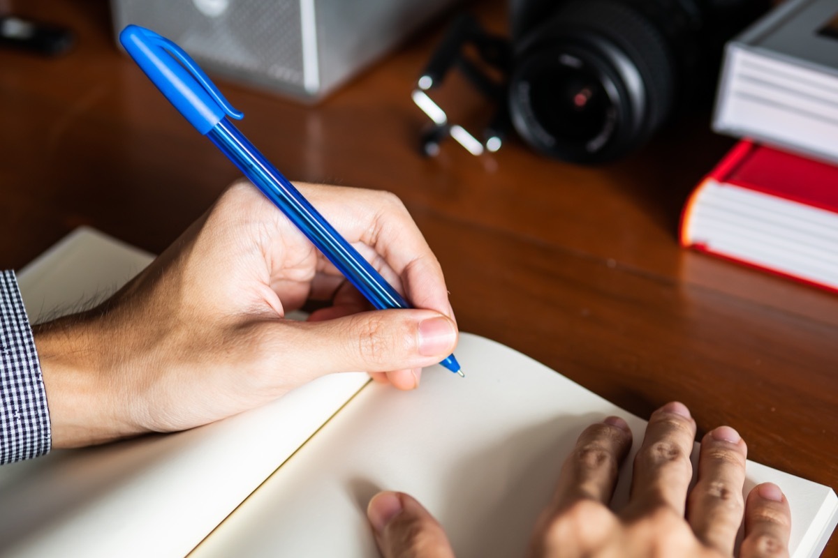 Lefty Writing in Notebook with blue pen, ways to feel amazing