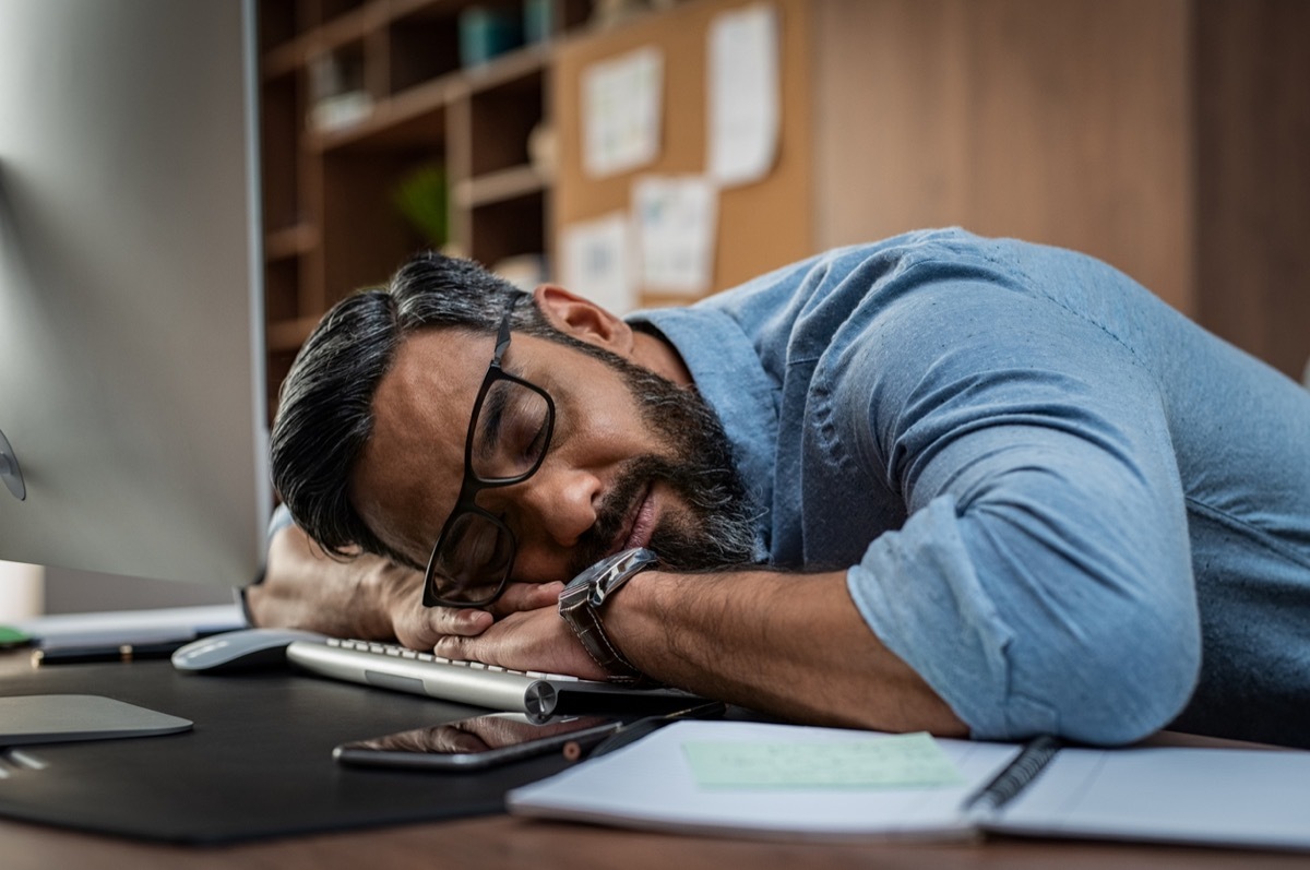 Tired multiethnic businessman sleeping in office