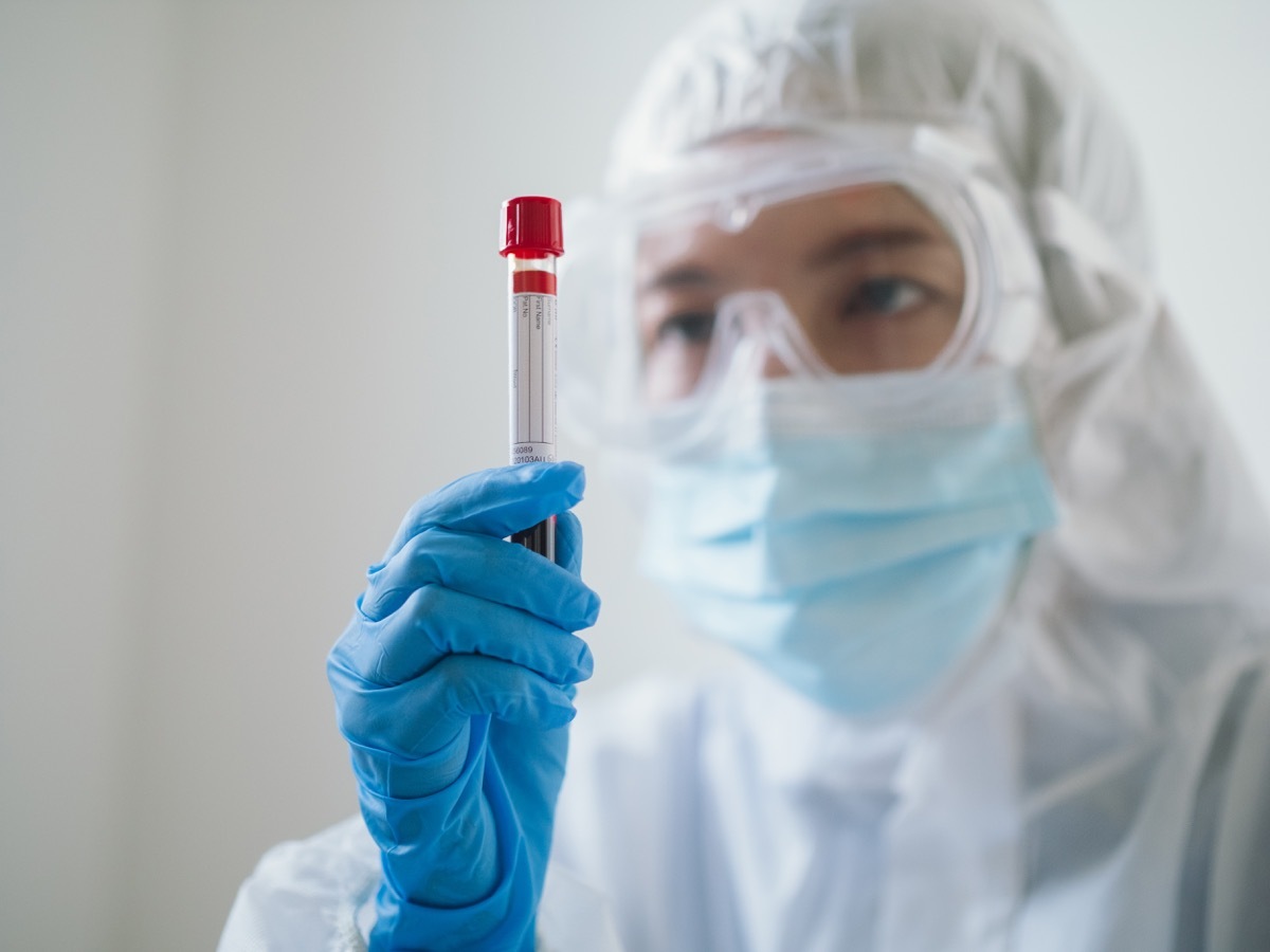 Female preparing blood for test with covid 19 vaccine at laboratory.