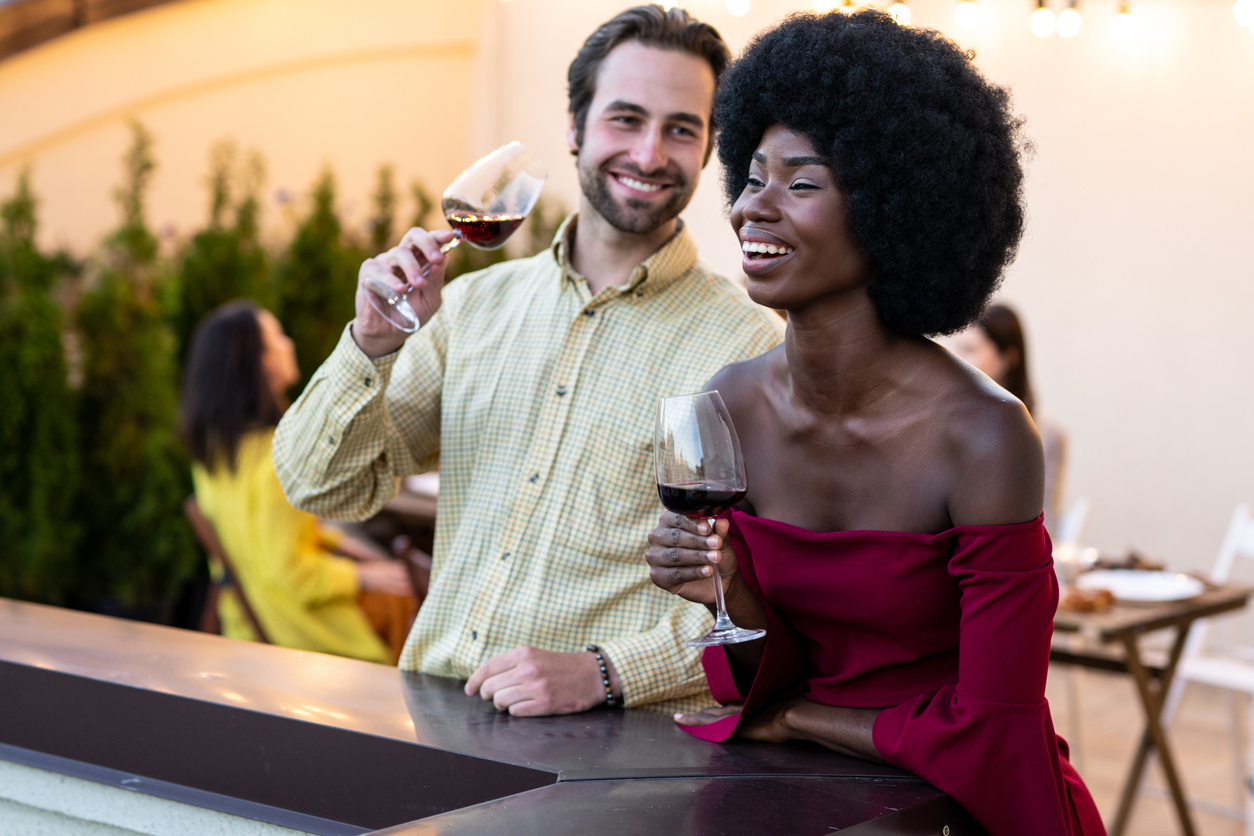 multiethnic group of people dining on a rooftop. Family and friends make a reunion at home, eating and having fun