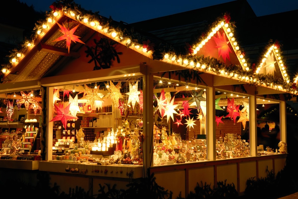 Illuminated Christmas fair kiosk with loads of shining decoration merchandise