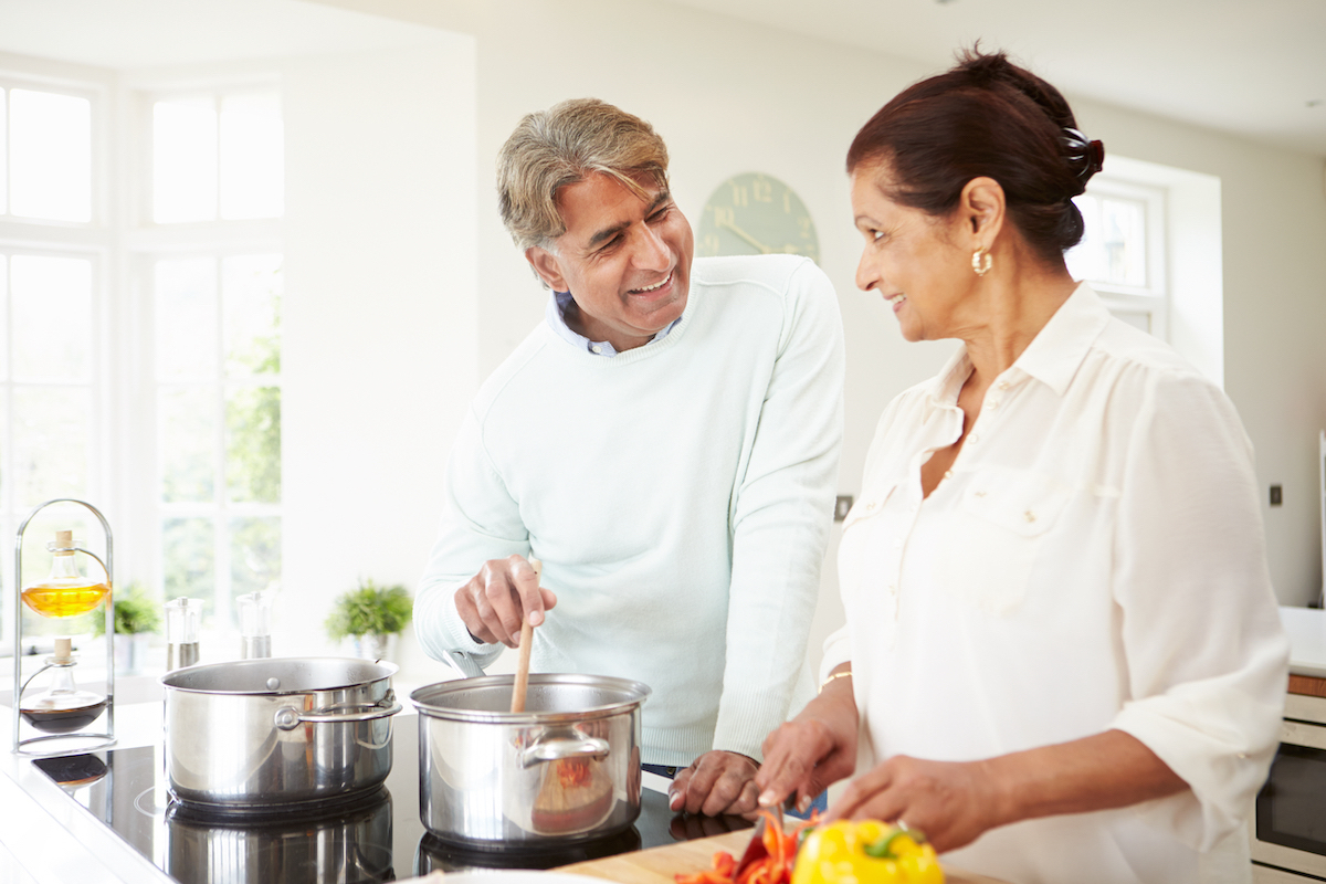 middle aged couple cooking