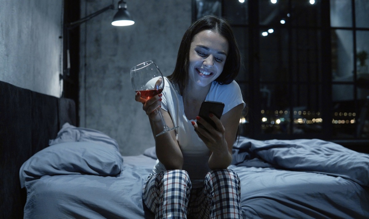 Woman chatting on the phone with a glass of wine