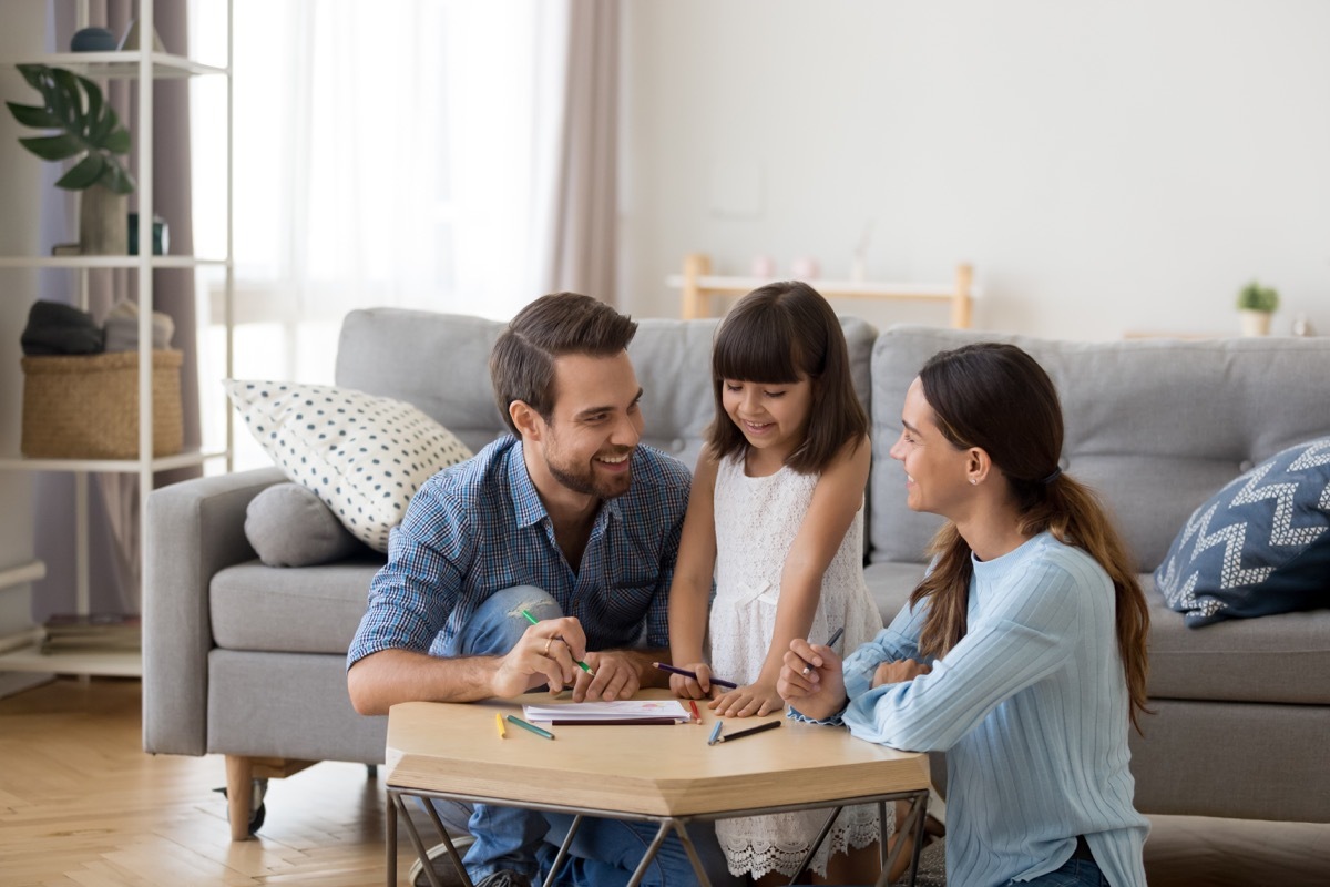 Mom dad and kid drawing and creating at home together