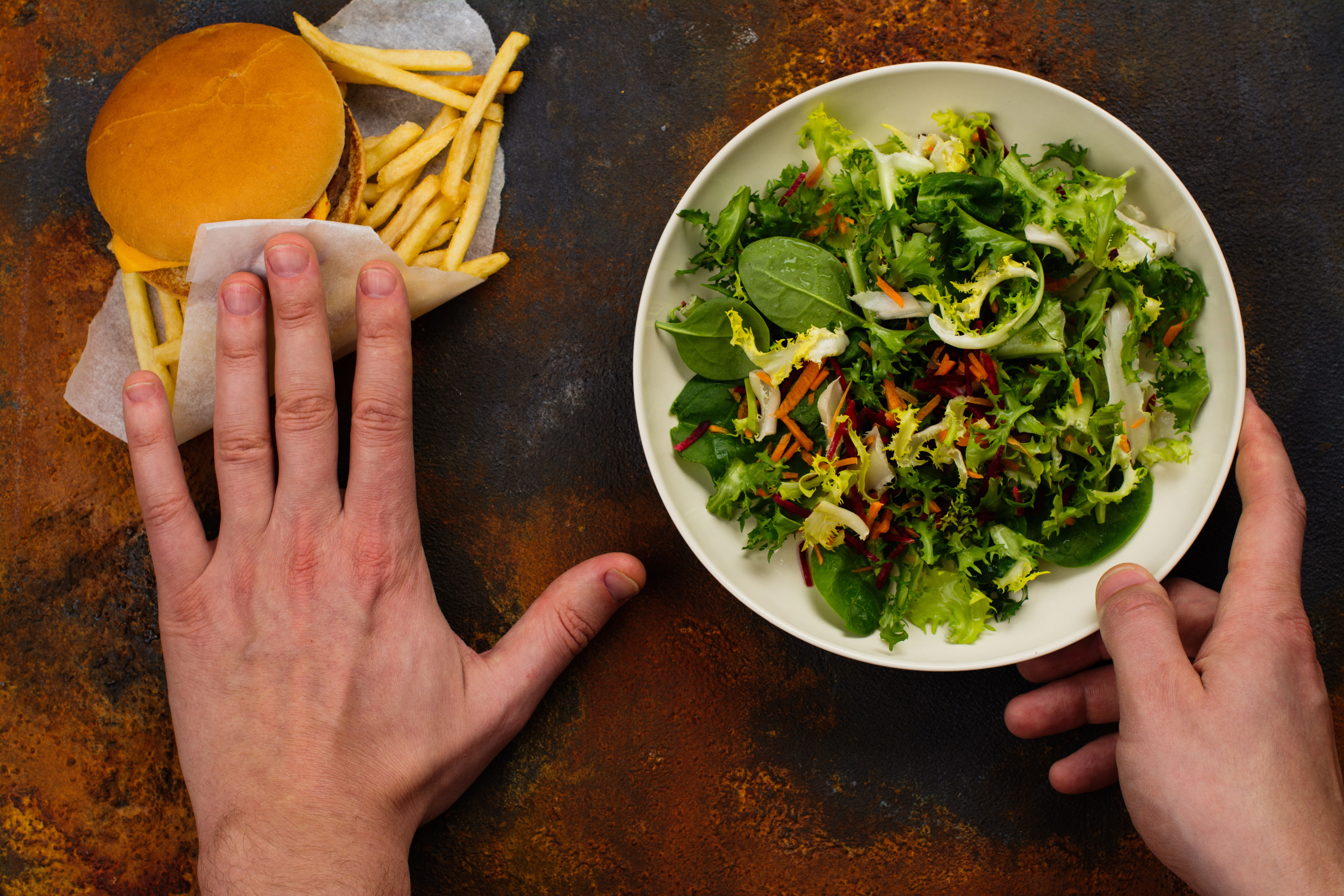 person deciding between a salad or a cheeseburger