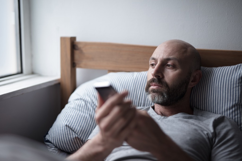 man looking sad in bed, worst things about an empty nest