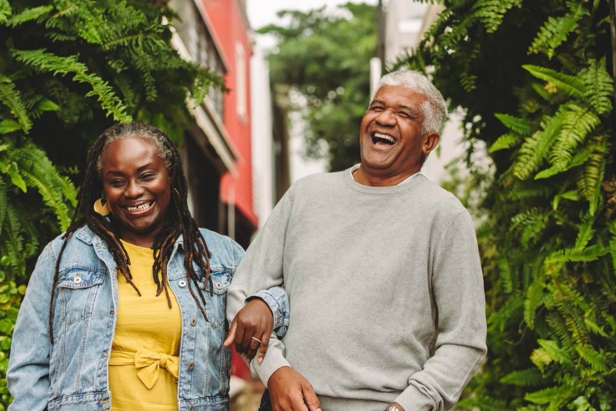 older man and woman walking arm and arm