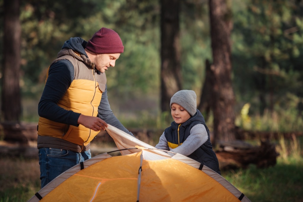 father and son putting up tent