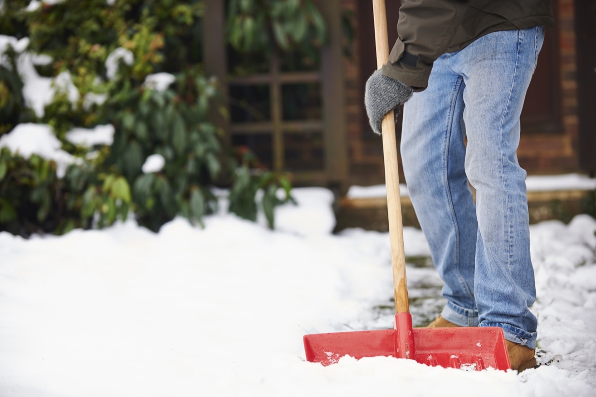 Man Clearing Snow From Path With Shovel